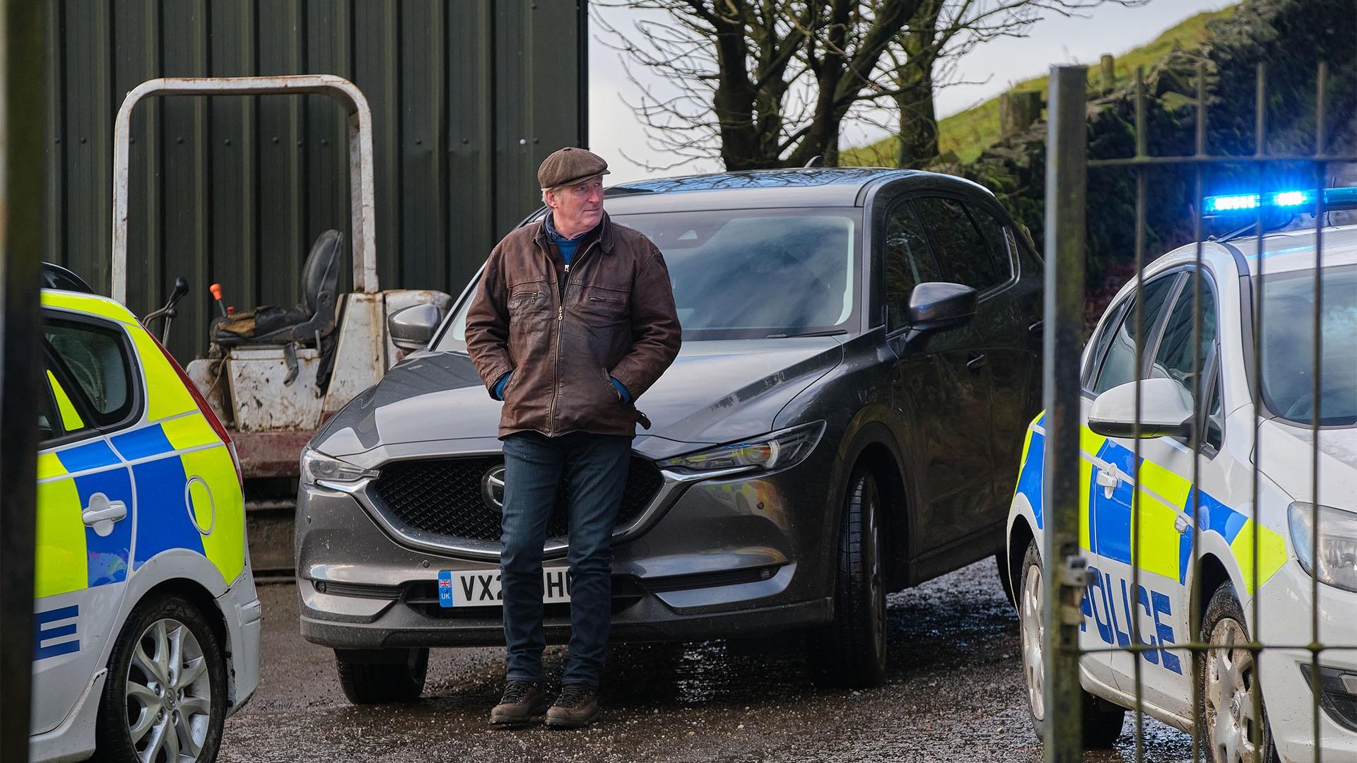 Alex Ridley leaning against car.